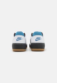 Zapatillas Nike con parte superior blanca, collar acolchado azul, entresuela negra y suela de goma, con el logo "Nike" en cada talón.