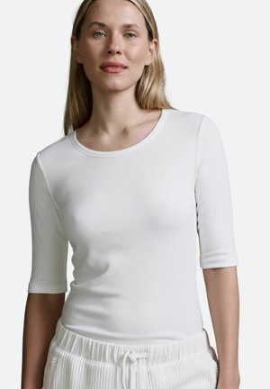 Weißes, geripptes Langarmshirt mit rundem Halsausschnitt, figurbetontem Schnitt und halblangen Ärmeln, kombiniert mit passenden, strukturierten Hosen.