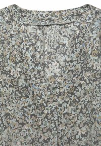 Top con stampa floreale in tessuto leggero, con scollatura a V, in tonalità di grigio, beige e azzurro chiaro. Superficie testurizzata e dettaglio plissettato.