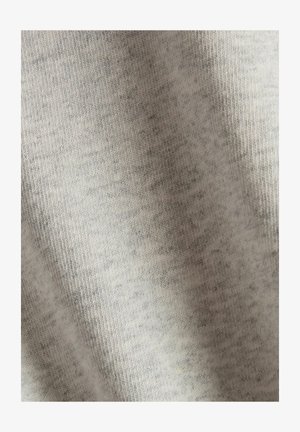 Lichtgrijze stof met een zachte textuur, met een subtiel gemêleerd patroon. Het materiaal lijkt rekbaar en licht van gewicht. Geen zichtbare hardware of accenten.