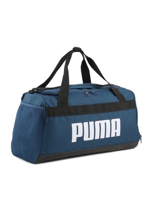 Sac polochon Puma bleu avec poignées noires, dessus zippé, poche latérale en mesh et grand logo Puma blanc sur le devant.