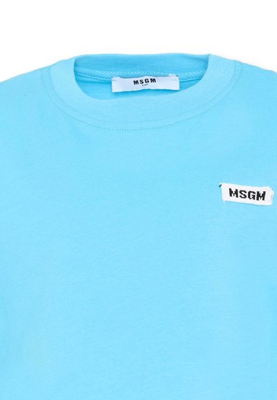 T-shirt bleu clair à col rond avec une petite étiquette blanche portant l'inscription "MSGM" sur la poitrine et une étiquette de marque en tissu à l'intérieur du col.