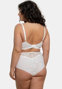 Ensemble de lingerie blanche comprenant un soutien-gorge à bretelles réglables avec des finitions en dentelle et une culotte taille haute avec des accents en dentelle à l'arrière.