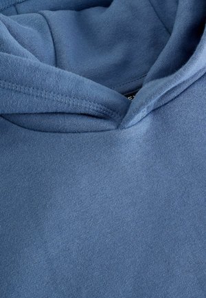 Hoodie bleu en tissu doux et texturé, avec capuche et coutures renforcées. L'encolure est arrondie avec une finition lisse.
