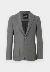 Grå skräddarsydd blazer i texturerad tyg, med spetsig krage, två framfickor och stängning med två knappar. Inuti finns en svart foder.