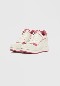 Λευκά και ανοιχτό ροζ αθλητικά παπούτσια με κορδόνια, σόλα με πλατφόρμα, πλαϊνά πάνελ με υφή και λαμπερή ασημένια λωρίδα στη μέση της σόλας. Στρογγυλεμένος σχεδιασμός μύτης.