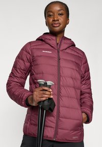 Μαρόν μπουφάν με επένδυση και κουκούλα, με αντικείμενο που έχει επενδυθεί και φερμουάρ. Ο κάτοχος για τα μπαστούνια πεζοπορίας είναι ορατός στα χέρια. Ανθεκτικό υλικό.