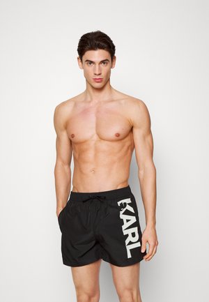Pantaloni da bagno neri con vita dotata di cordoncino e grande testo bianco "KARL" sul lato. Realizzati in materiale leggero, adatti per attività acquatiche.