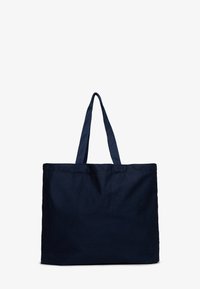 Granatowa torba na ramię wykonana z trwałego materiału, z dwiema długimi rączkami i prostym, nieozdobionym designem. Kwadratowa podstawa.