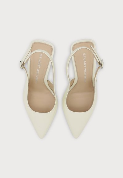 Paire d'escarpins slingback crème à bout pointu avec brides de cheville et semelles beiges affichant la marque "Stuart Weitzman".
