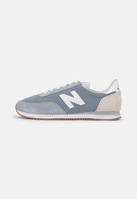 Sneaker in mesh e suede blu con branding bianco, profilo basso e suola in gomma naturale, dotate di un design con lacci e accenti sottili.