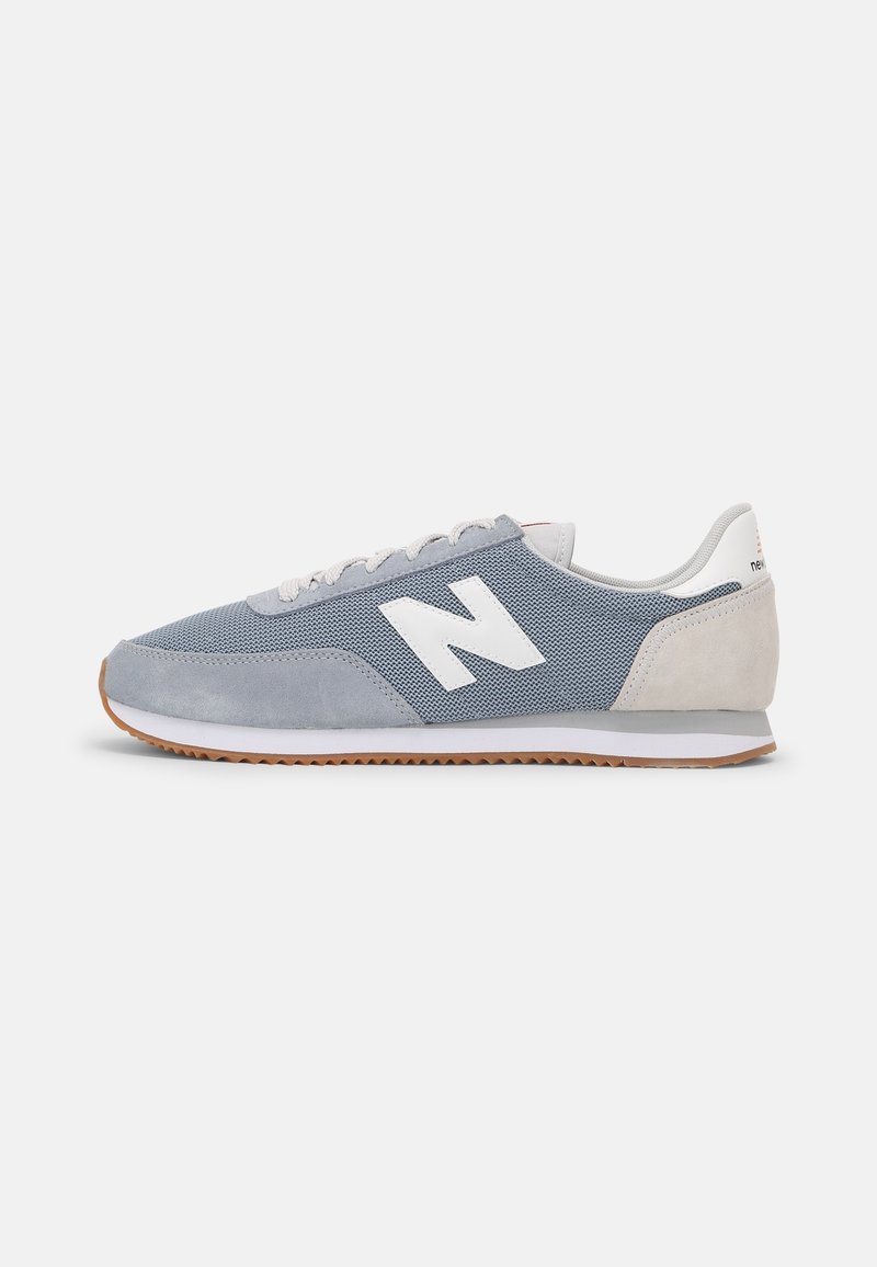 Sneaker in mesh e suede blu con branding bianco, profilo basso e suola in gomma naturale, dotate di un design con lacci e accenti sottili.