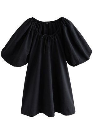 Robe noire ample avec manches bouffantes aux coudes et encolure ronde froncée avec un petit nœud.