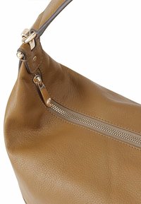 Bruine leren schoudertas met een gestructureerde afwerking, een gouden ritsluiting en een slank, gebogen ontwerp met een enkele band.