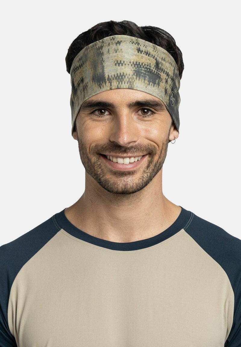 Cinta para la cabeza en una paleta de colores terrosos apagados con un patrón abstracto. Hecha de tela suave y elástica, se ajusta cómodamente alrededor de la cabeza.