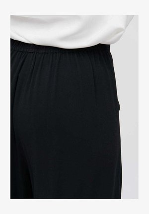 Black tapered pants with an elastic waistband. Made of soft fabric, featuring subtle pleats for added texture. Ideal for casual wear.