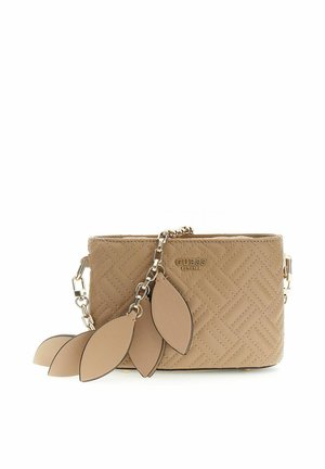Sac bandoulière matelassé beige de Guess avec chaîne dorée et charms décoratifs en forme de feuilles en cuir beige suspendus à l'avant.