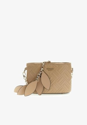 Sac bandoulière matelassé beige de Guess avec chaîne dorée et charms décoratifs en forme de feuilles en cuir beige suspendus à l'avant.
