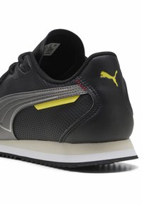 Mustad mustus sneaker, millede nahk, hallid aktsendid, kollane triip ja valge vahekiht. Varustatud tekstuurse kummist välispinna ja logoga.