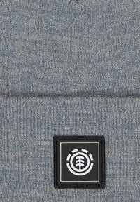 Czapka dzianinowa w heatherowanym niebieskim kolorze, z czarną prostokątną naszywką z białym logo drzewa i okrągłym wzorem. Miękka tekstura, dobrze dopasowana.