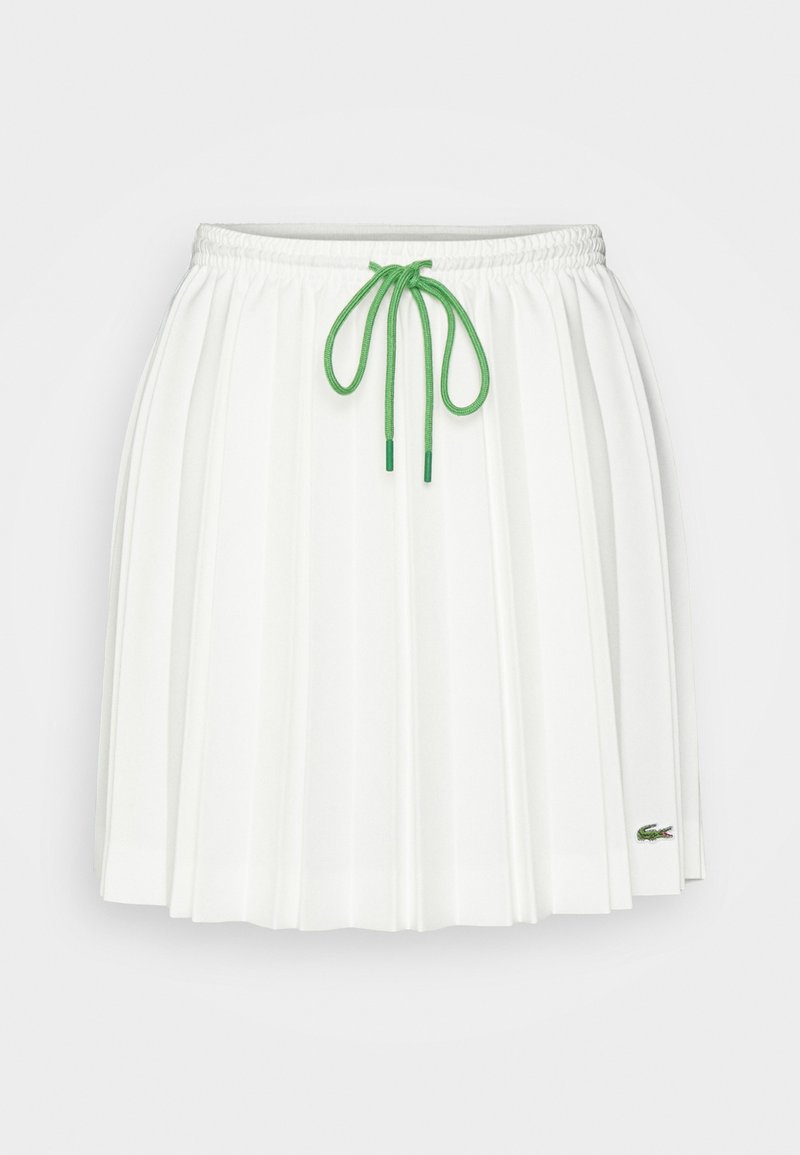 Weißer plissierter Rock mit elastischem Bund und grünem Kordelzug, ausgestattet mit einem kleinen gestickten grünen Krokodil-Logo in der Nähe des Saums.