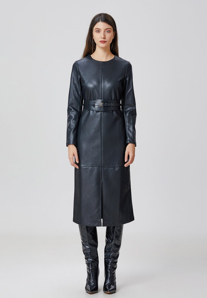Robe longue en cuir noir à manches longues avec un col rond et une ceinture. Présente une silhouette droite, une fente à l'avant et une texture lisse.