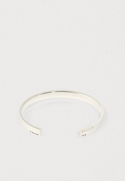 Minimalistična odprta srebrna zapestnica s graviranim napisom "le gramme," "925" in oznakama teže na koncih.