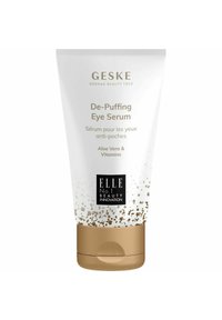 Tubo di siero de-puffing per gli occhi con corpo bianco lucido, accenti dorati e design testurizzato. L'etichetta include ingredienti: Aloe Vera e Vitamine.