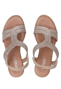 Open-toed sandalen met een tan kleurige basis, voorzien van gevlochten metalen banden versierd met heldere kralen, en een gestructureerde zool.