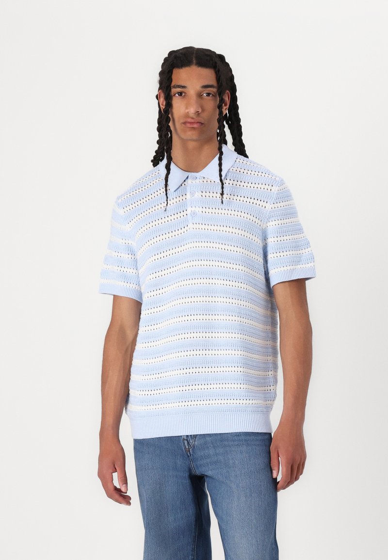 Blå kortærmet polo t-shirt med strikket design, der har vandrette striber og hulmønstre. Ribbet kant og krave, suppleret med lyseblå detaljer.