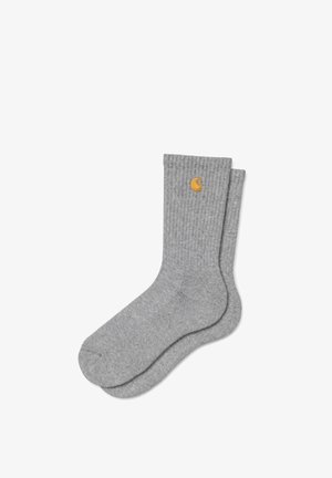 Paar hellgraue, gerippte Sneakersocken mit kleinem gelben Sticklogo nahe am oberen Rand auf weißem Hintergrund.
