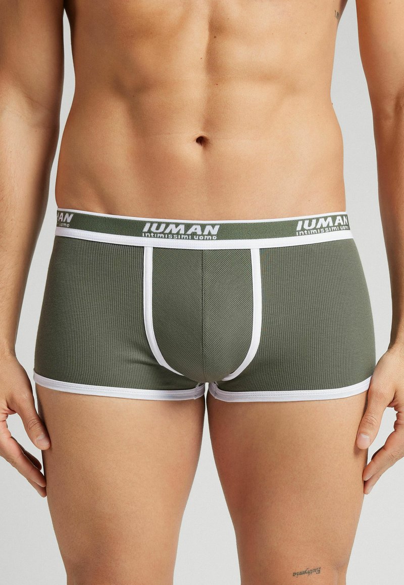 Olivově zelené žebrované boxerky s bílým elastickým pasem označeným "IUMAN," s kontrastním lemem a přiléhavým střihem.