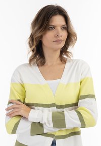 Cárdigan ligero de manga larga con atrevidas rayas horizontales en amarillo, blanco y verde oliva. Diseño de escote en V con puños acanalados.