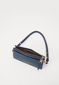 Sac bandoulière en cuir bleu marine avec une texture lisse, deux compartiments zippés et des accents en métal doré. Sangle d'épaule réglable incluse.