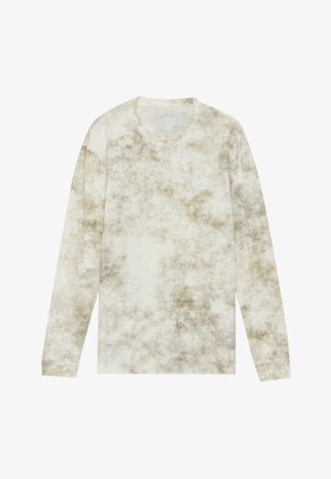 Dlhý rukáv v svetlej béžovej farbe s tie-dye vzorom v tmavších odtieňoch. Má okrúhly výstrih a malé logo na hrudi. Mäkká textúra.