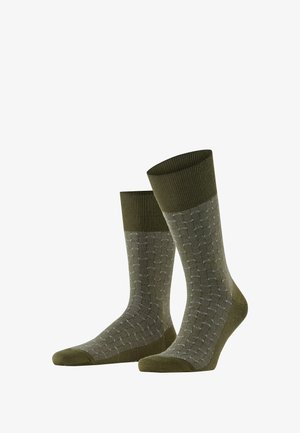 Olivgrüne Socken mit einem gerippten Bündchen und geometrischem grauen Muster. Aus einem weichen Material gefertigt, mit verstärkten Zehen- und Fersendetails.