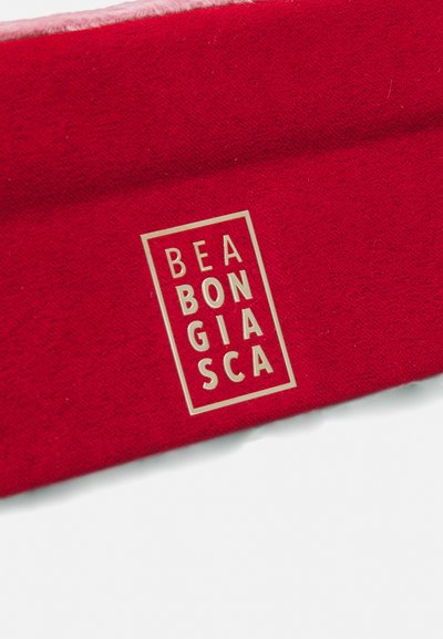 Rød stoffhodebånd med en myk tekstur, med en gulllogo-plakett som viser "BEABONGIASCA" på en fremtredende måte.