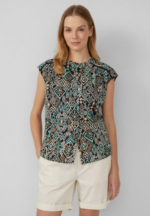 Blouse sans manches noire à motifs géométriques turquoise et beige. Elle présente un col rond et un tissu doux.