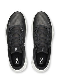 Scarpe da ginnastica nere con tomaia in mesh traspirante, accenti grigi, sistema di allacciatura tradizionale e suola bianca ammortizzata con logo.