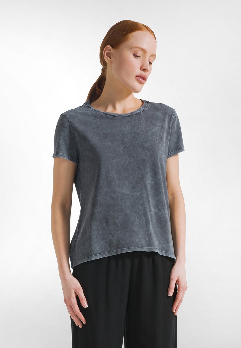 Grijs katoenen t-shirt met korte mouwen, ronde hals en een losse pasvorm. Licht gestructureerd oppervlak met subtiele kleurvariaties.