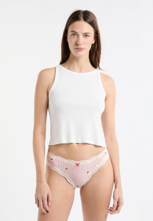 Débardeur blanc court en tissu doux, associé à un sous-vêtement rayé rose et blanc avec une bordure en dentelle et des accents rouges.