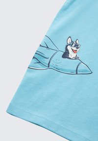 Light blue cotton t-shirt with a graphic of a husky wearing sunglasses, sitting on a blue rocket. Smooth texture, short sleeves, and rounded hem.