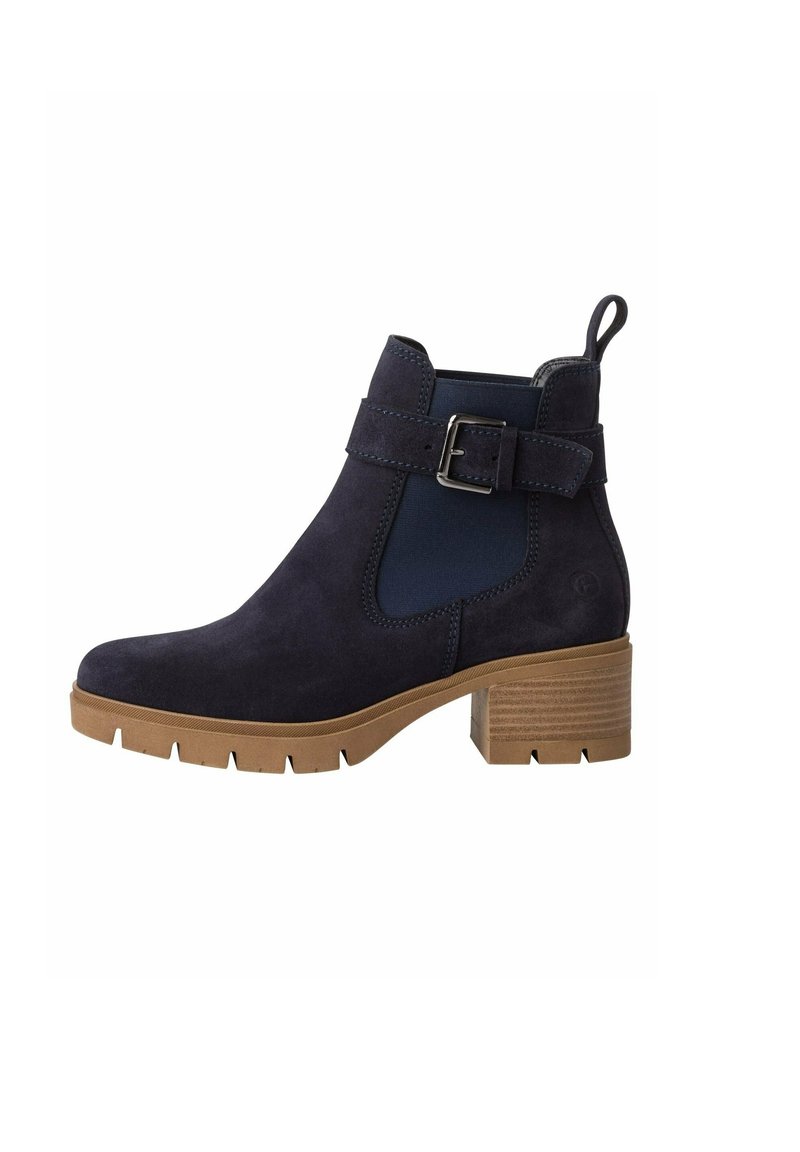 Bottine en suedine bleu marine avec panneau latéral élastique, accent en boucle et talon bloc en brun texturé. Semelle robuste avec rainures de traction.