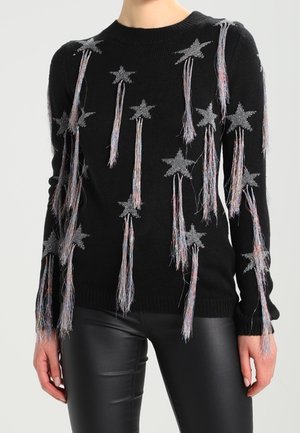 Maglione nero a maglia con applicazioni di stelle argento e fili colorati con frange che pendono da esse. Maniche lunghe e scollatura a girocollo.
