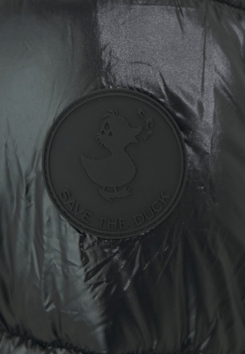 Giacca imbottita nera con logo rotondo in gomma nera raffigurante un cartone animato di un'anatra e il testo "SAVE THE DUCK", tessuto liscio e lucido.