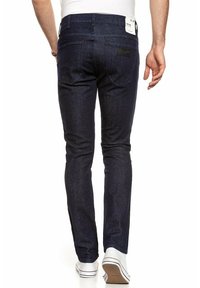 Granatowe dżinsy o kroju slim, z tylnymi kieszeniami i markową naszywką. Wytrzymały materiał o gładkiej fakturze.