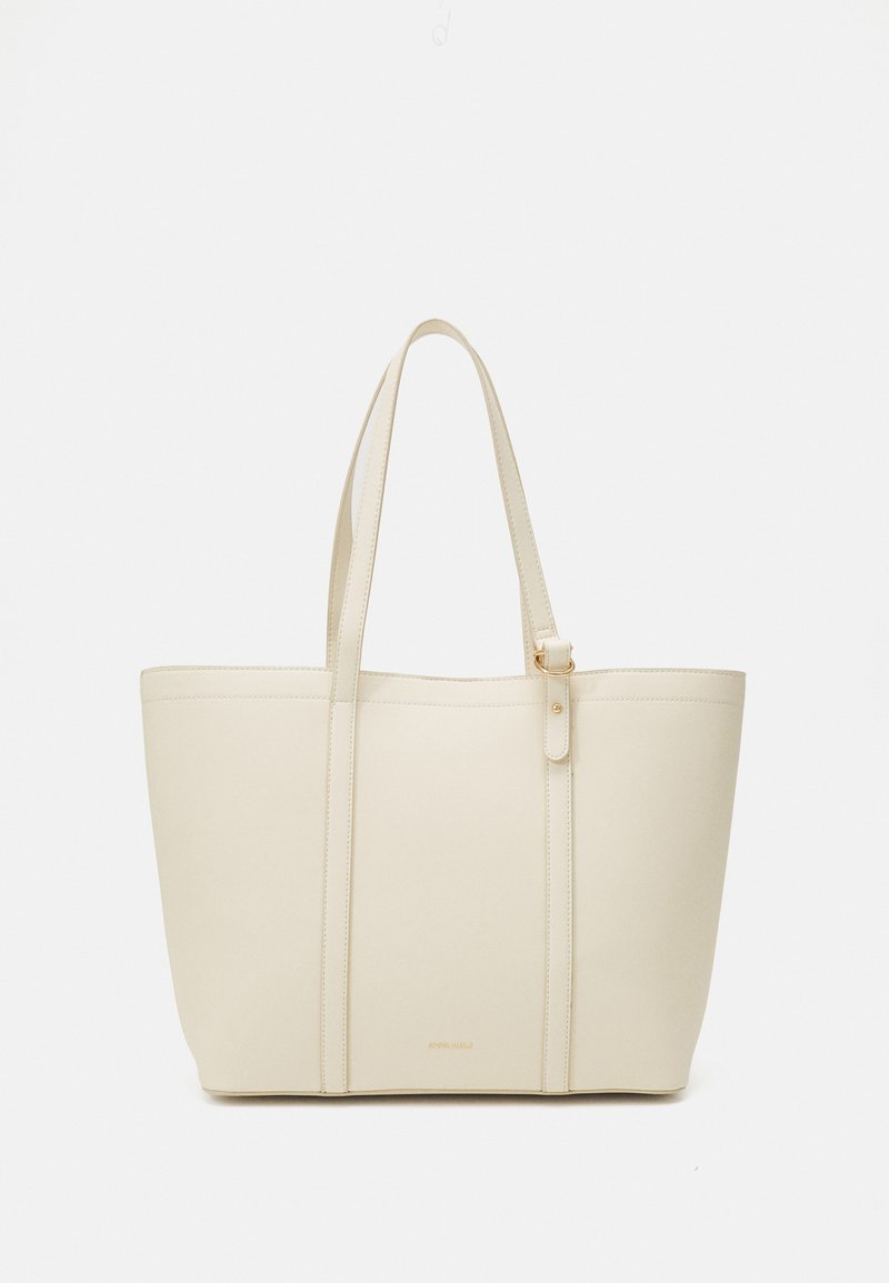 Sac fourre-tout beige fabriqué en matériau synthétique lisse. Dispose de deux longues poignées et d'un design simple et structuré avec des coutures minimalistes.