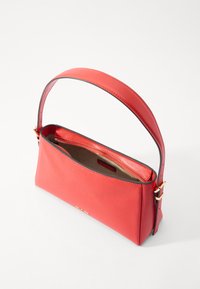 Sac à main en cuir rouge avec une finition texturée, une poignée courte à épaule et une poche intérieure zippée. Dispose de peu de matériel et d'un intérieur doublé.