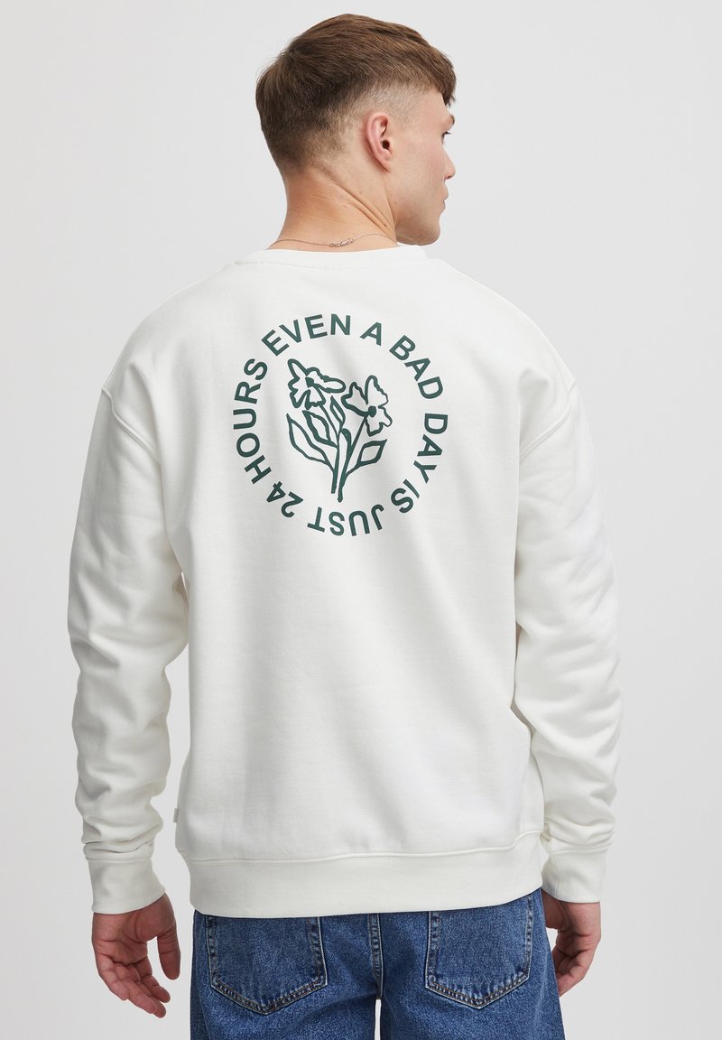 Hvid sweatshirt med grønne blomster grafikker og tekst på ryggen. Ribbetærmer og -kant; afslappet pasform med blød tekstur.