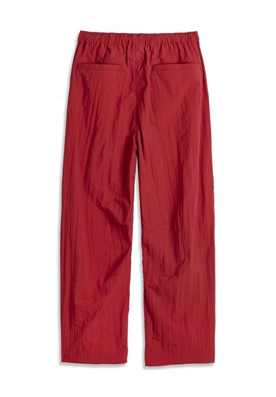 Pantalon rouge à coupe décontractée avec taille élastique et deux poches plaquées arrière, présenté à plat sur un fond blanc.